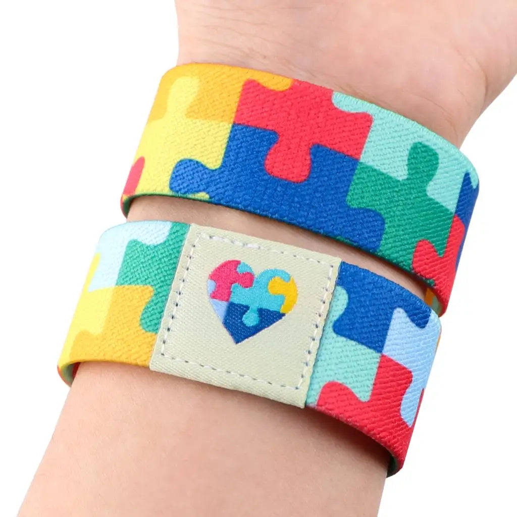 Pulseira com pingente de quebra-cabeça colorido, símbolo do autismo. Ajustável, elegante e feita para apoiar a inclusão com estilo.